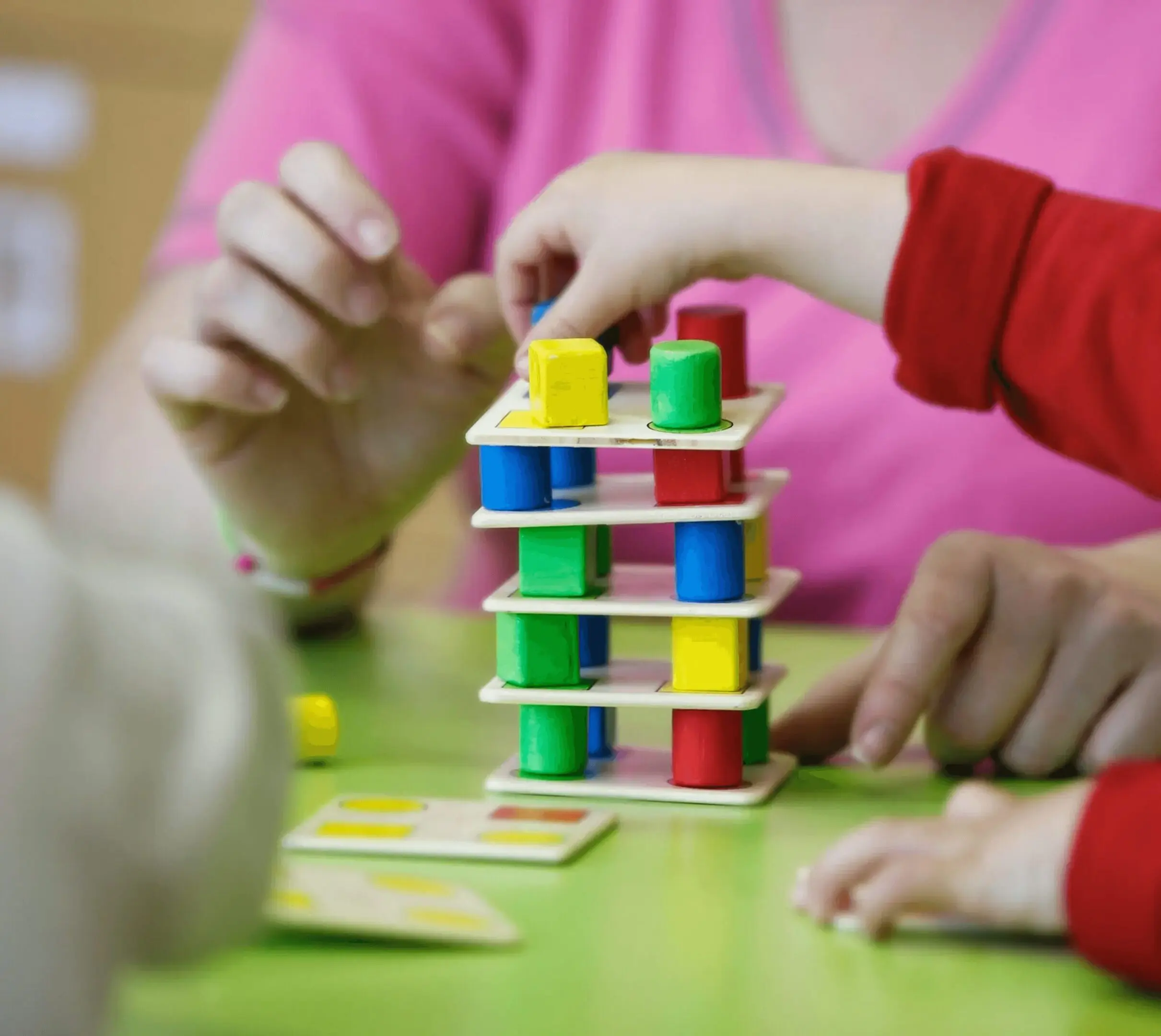93133 1 (1) Children playing with colorful stacking blocks.